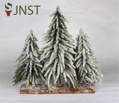 Kleine kerstboom voor Kerstmis met houten basis